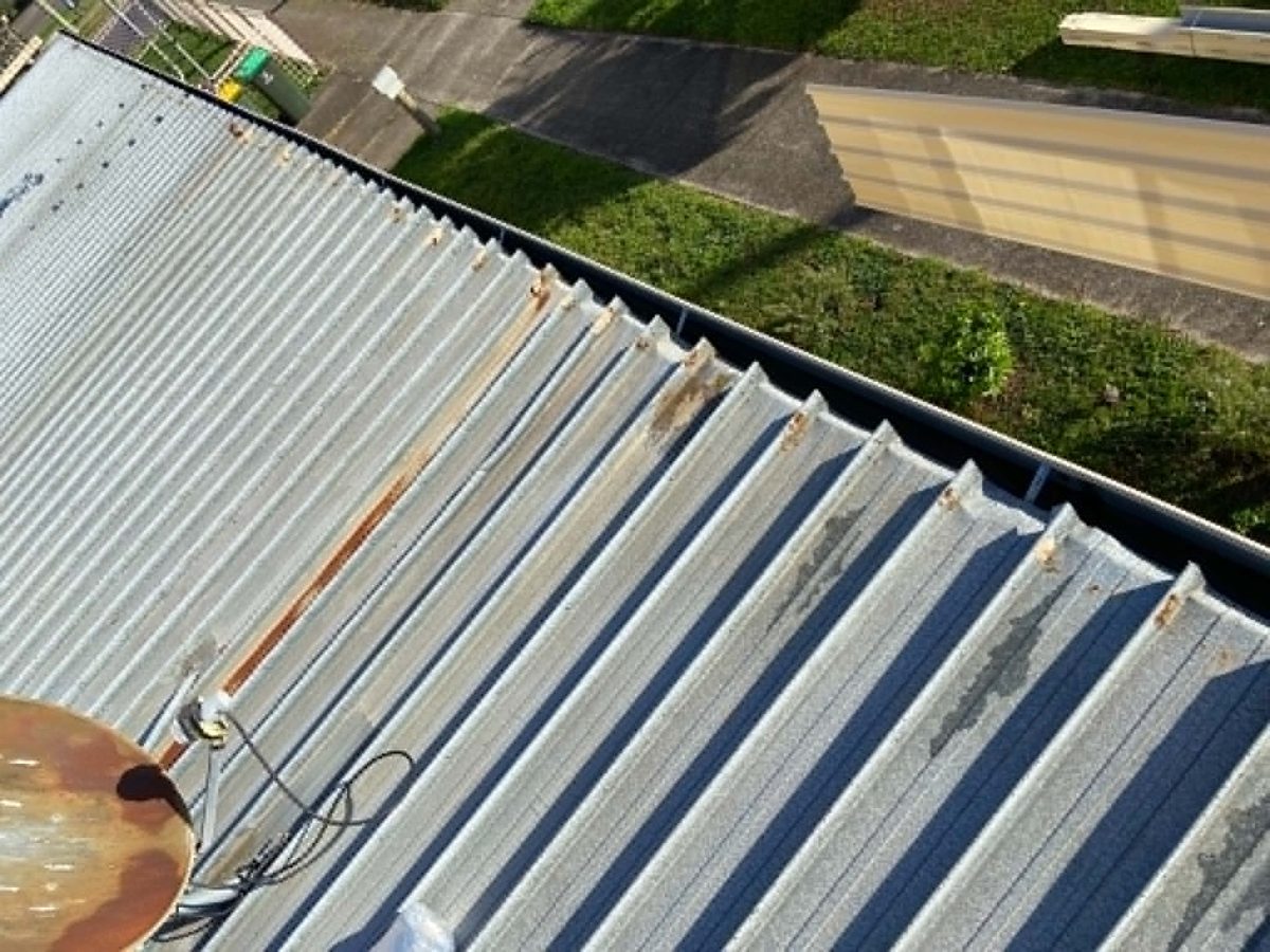 Before: rusted sheeting and failing gutters